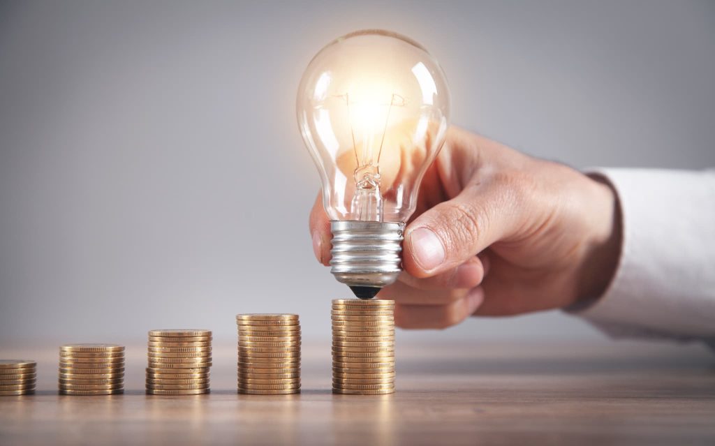 右肩上がりに積まれた金貨に電球を合わせ、即日の資金調達によるキャッシュフロー改善や急な事業資金の確保、その後のビジネス成長をイメージさせる