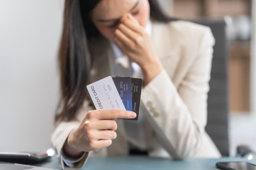 複数の社から借り入れたカードローンの返済や資金繰りに悩み頭を抱えている個人事業主の女性