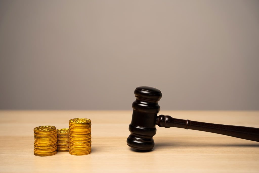 督促状を無視し続けた場合に起こり得る法的措置や裁判および差し押さえを示唆する木槌と積み上げられた硬貨