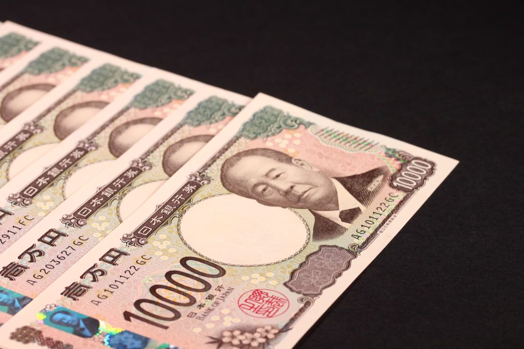 新規事業の資金調達や補助金の活用をイメージさせる、黒い背景の上に並べられた一万円札の束