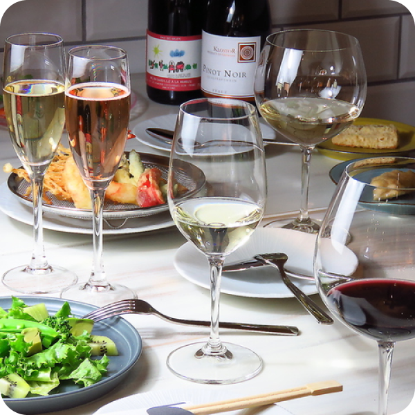 写真：テーブルに置かれたワイングラスや料理