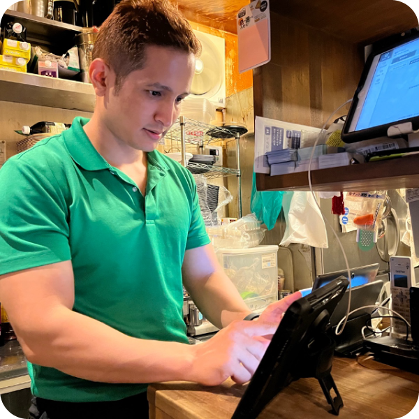写真：タブレットを操作するスタッフ