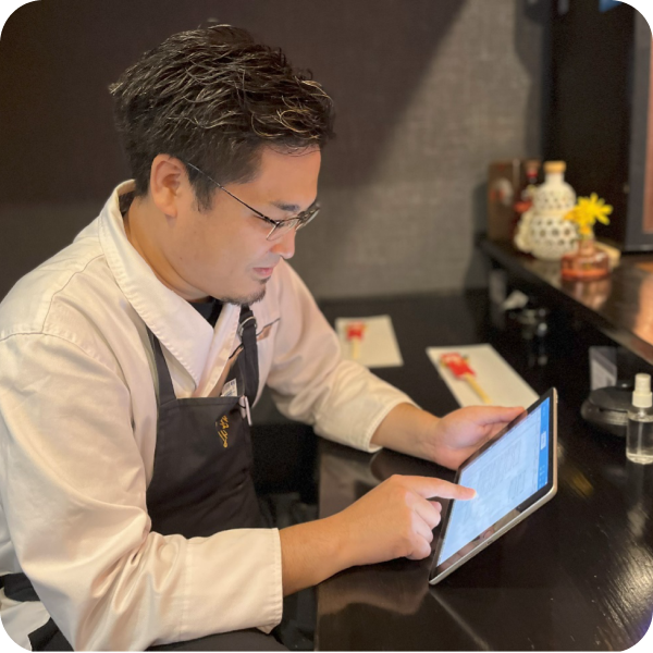 写真：タブレットを操作するスタッフ