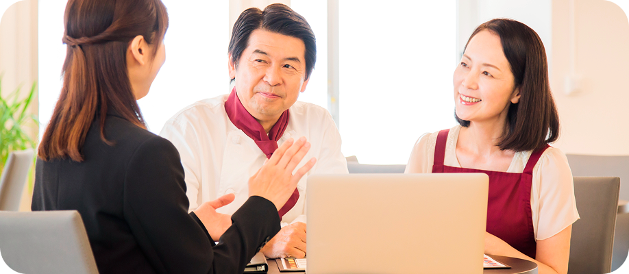 写真：担当者から説明をうける男女