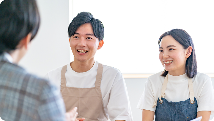 写真：専任スタッフと会話する2名の店舗スタッフ