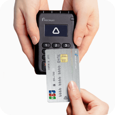 クレジットカードとカードリーダーでタッチ決済する画像
