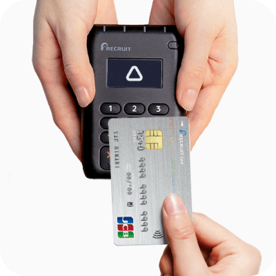 クレジットカードとカードリーダーでタッチ決済する画像