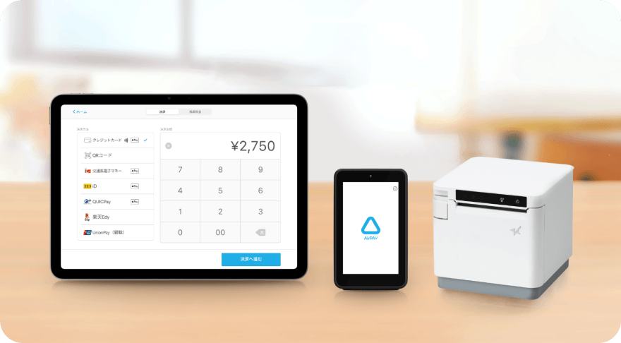 Airレジの決済画面を表示したiPadとカードリーダーとレシートプリンターがテーブルの上に並んでいる画像。
