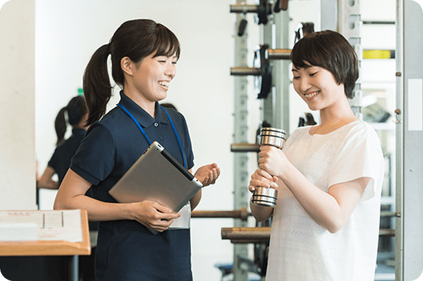 ジムのトレーナーとお客さんが話している様子