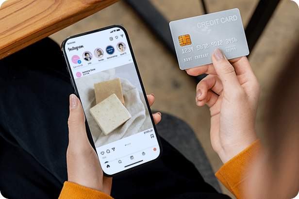 スマートフォンでSNSを開いて、クレジットカードを持っている写真