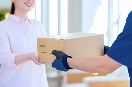 商品を配達員から受け取っている様子の写真