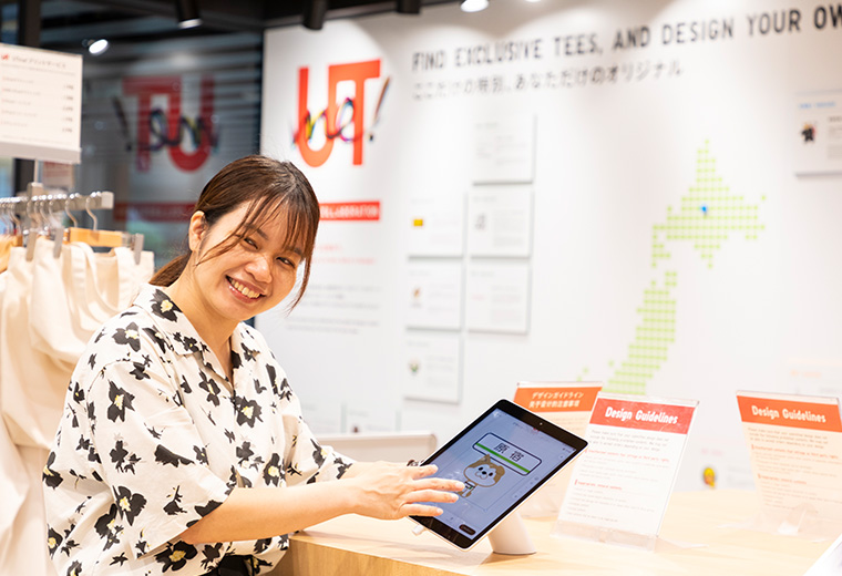 写真:ユニクロ 原宿店様のスタッフが「UTme!」の説明をしている様子