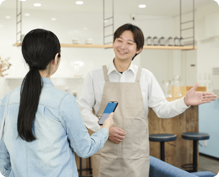 写真：朝食会場で順番案内されるお客様と対応するスタッフ