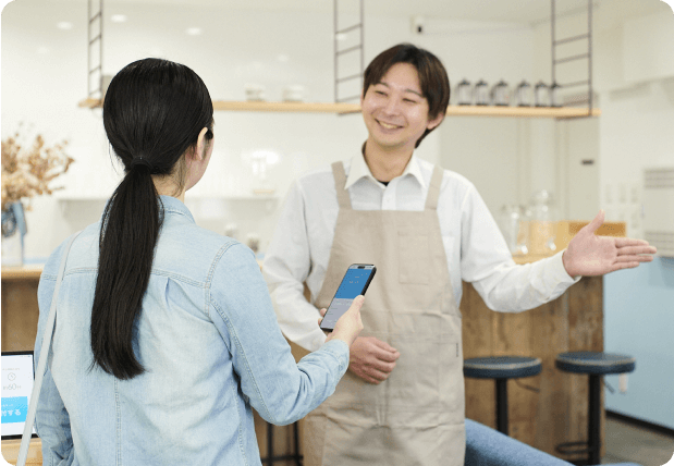 写真：朝食会場で順番案内されるお客様と対応するスタッフ